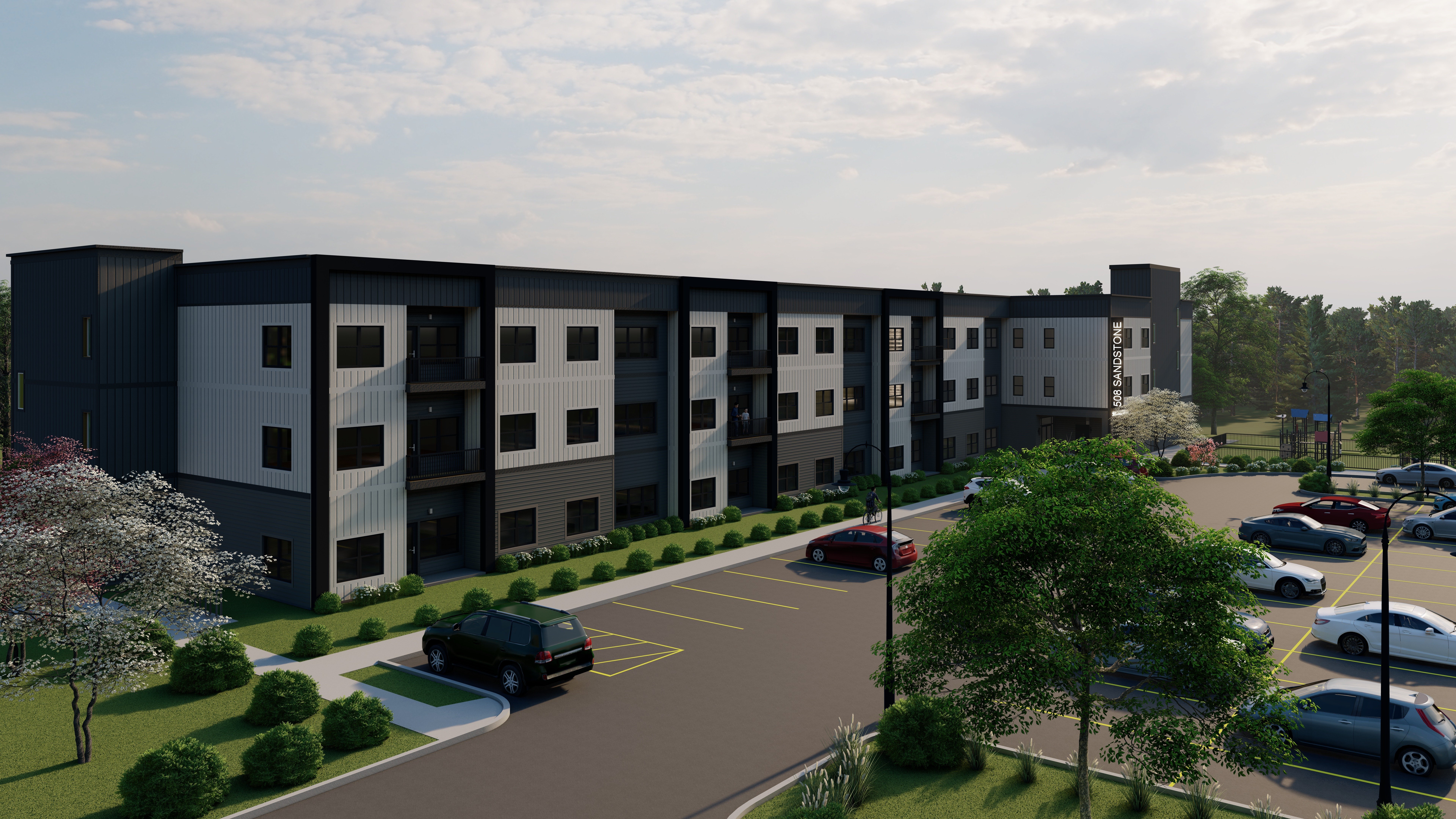 A modern apartment complex with a parking lot in front.